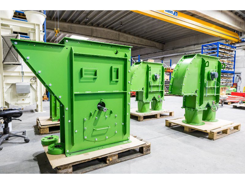 Delen van een elevator voor een stenenproducent, voorzien van slijtplaten; links de voet en rechts de kop.