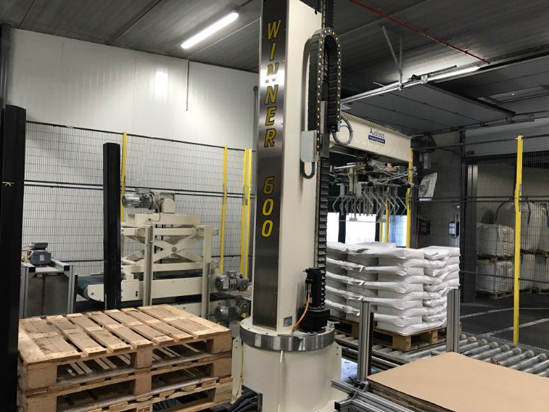Palletplaats op rollenbaan. De robot pakt een lege pallet en een kartonnen vel
