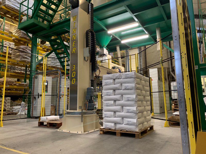 De robotpalletiser is compact en kan snel omschakelen tussen zakformaten en stapelpatronen. Hier in een versie die op 2 pallets op de vloer stapelt