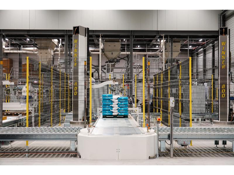 Door Ausloos ontworpen en geïnstalleerde verpakkingslijn met een gerobotiseerde palletstapelaar